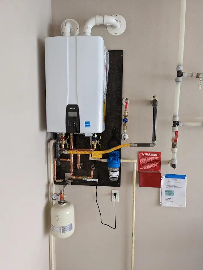 Professional plumber installing copper piping in a Wilna home